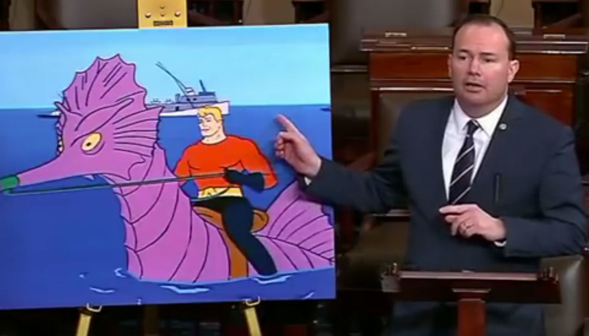 Senator Mike Lee pointing at a picture of Aquaman riding an enormous seahorse