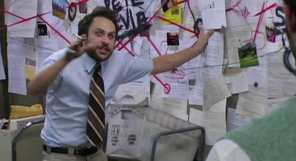 Charlie Reynolds from It's Always Sunny in Philidelphia, looking deranged as he tries to explain the multitude of connections between pieces of paper on a corkboard behind him